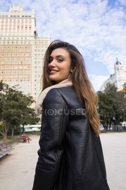 Stylish woman walking on park and looking over shoulder at camera — Stock Photo