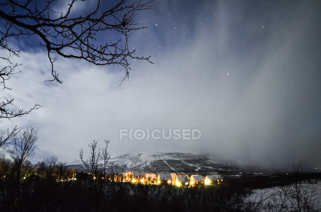 Vista a distanza al piccolo villaggio del nord e paesaggio invernale di notte . — Foto stock