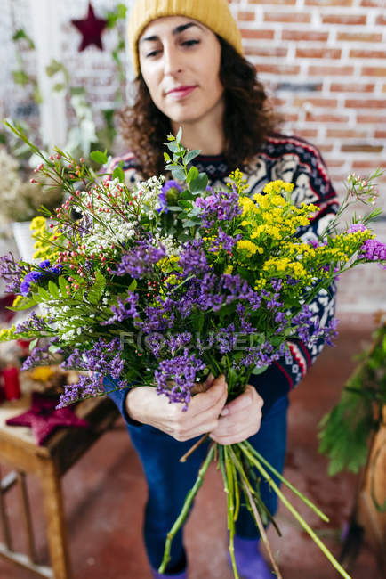 Portrait of cheerful woman holding bouquet in hands — Stock Photo