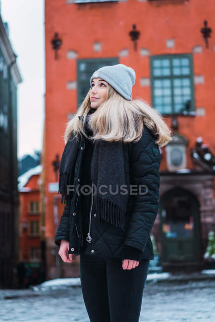 Вид сбоку блондинки в зимнем наряде, позирующей на зимней улице — город, Женский пол - Stock Photo