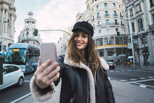 Brunette femme prendre selfie dans la rue — Photo de stock