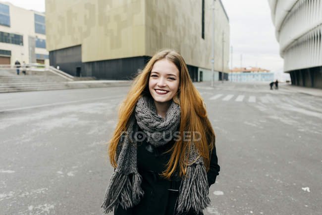 Portrait of smiling woman walking on street and looking at camera — Stock Photo