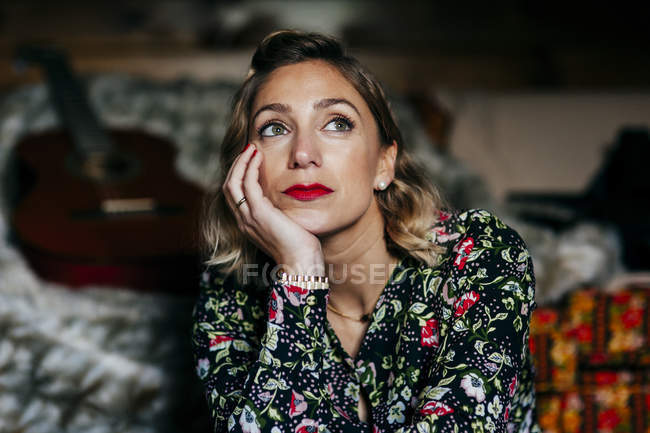 Dreamy adult pretty woman sitting at home and looking away. — Stock Photo