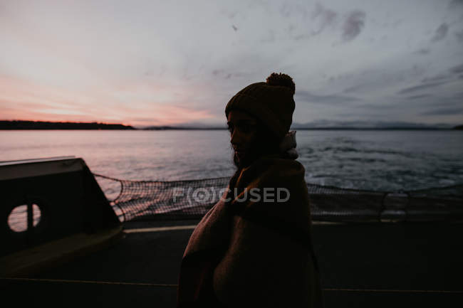 Silhueta de mulher de pé no navio ao entardecer — Fotografia de Stock