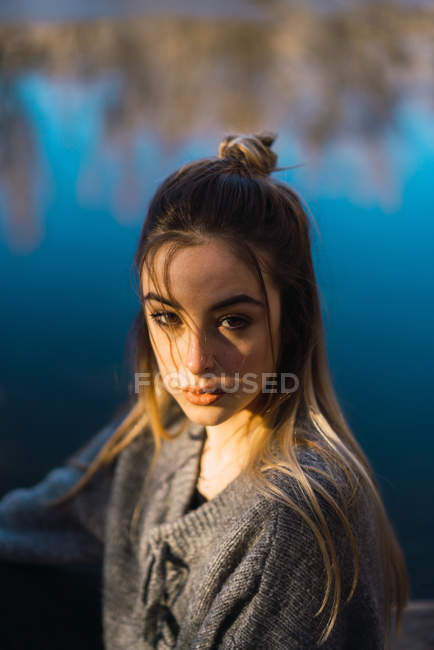 Ritratto di donna che posa sopra lo stagno e guarda la macchina fotografica — Foto stock