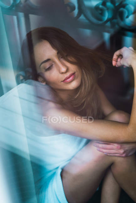Портрет жінки, що сидить біля вікна і розслабляється з закритими очима . — стокове фото