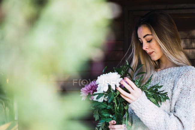 Vista laterale della donna romantica con fiori sul portico dello chalet — Foto stock