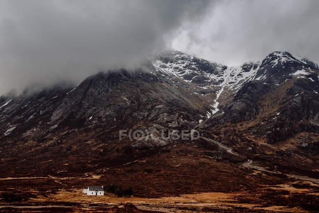 Vista distante a casa bianca a grande montagna nebbiosa — Foto stock