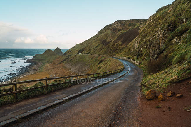 Vista panorámica a las verdes rocas costeras y la carretera en la costa - foto de stock