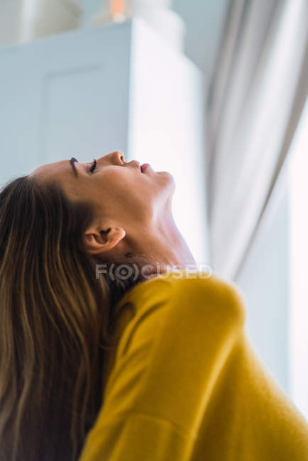 Vue latérale de la femme séduisante jetant la tête arrière — Photo de stock