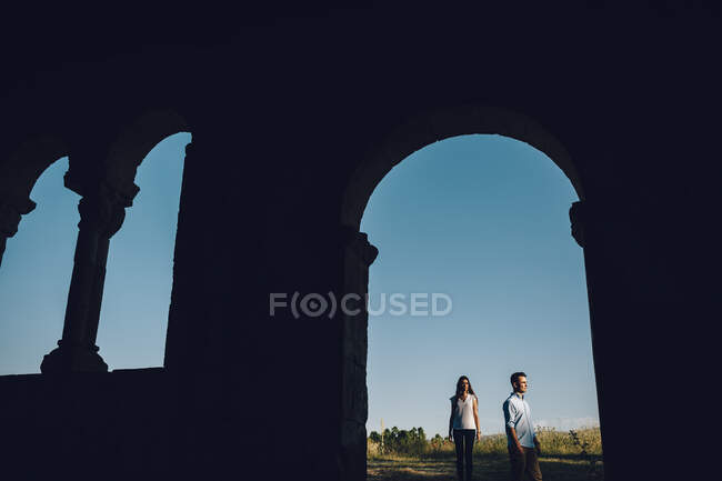 Ritratto di una coppia incorniciata in un arco di chiostro al tramonto in mezzo al campo a Madrid, Spagna — Foto stock