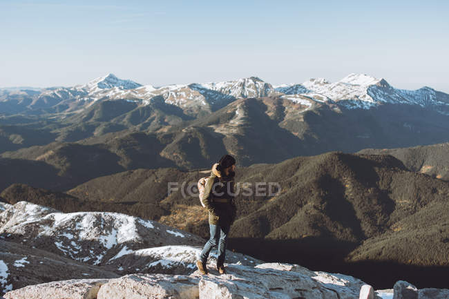 Вид сбоку человека в верхней одежде на фоне снежных гор — стоковое фото