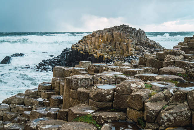 Вид на кам'яні утворення на березі океану в похмурий день — стокове фото