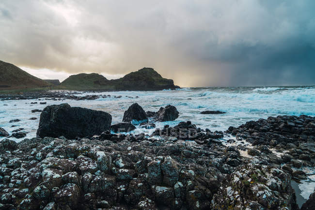 Vista panorámica de piedras y colinas a orillas del mar - foto de stock