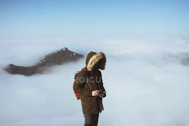 Man on rocky cliff in clouds — Stock Photo