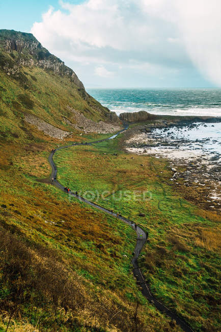 Piccola strada sul pendio della collina che corre in riva al mare — Foto stock