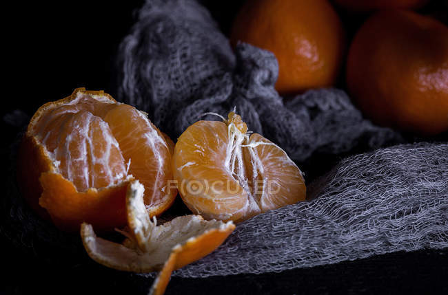 Nature morte de mandarines fraîches tranchées sur une vieille table en bois — Photo de stock