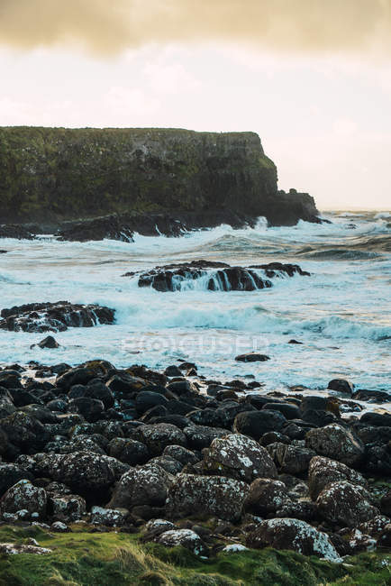Vue paysage sur les rochers et les pierres à la ligne ondulée de l'océan — Photo de stock