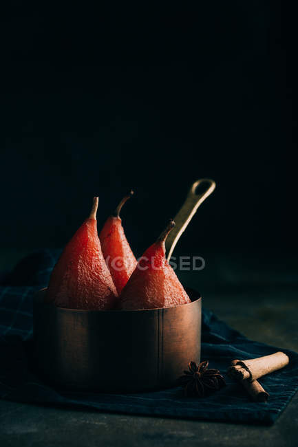 Still life of poached in red wine pears in copper sauce pot — Stock Photo