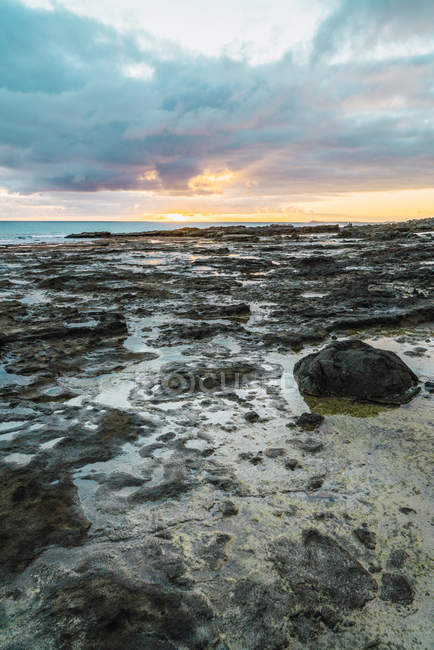 Close up view of shoreline formations with cloudy sky on background — Stock Photo