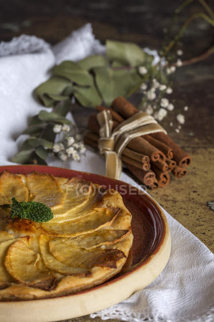 Crop delicious homemade apple pie and cinnamon sticks — Stock Photo