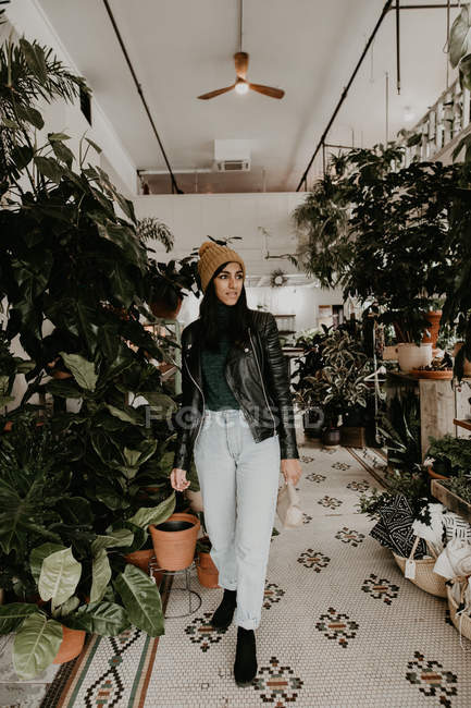 Pretty young woman walking in greenhouse — Stock Photo