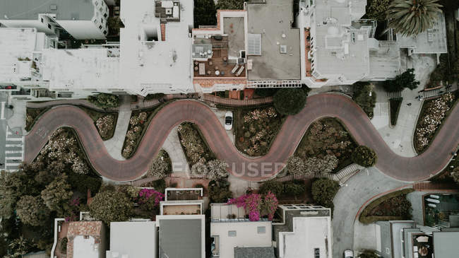 From above aerial view to snake shape road in urban town. — Stock Photo