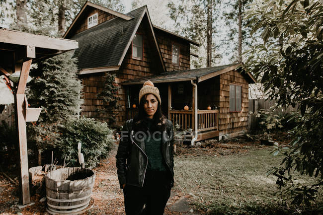 Jolie femme sur fond de maison en bois en forêt — Photo de stock