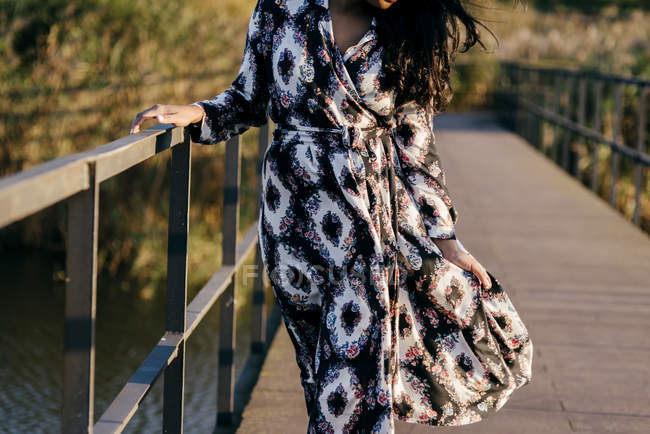 Crop donna in bel vestito in posa sul ponte — Foto stock