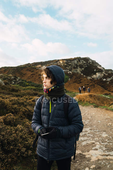 Retrato de turistas caminando sobre una colina soleada y mirando hacia otro lado - foto de stock
