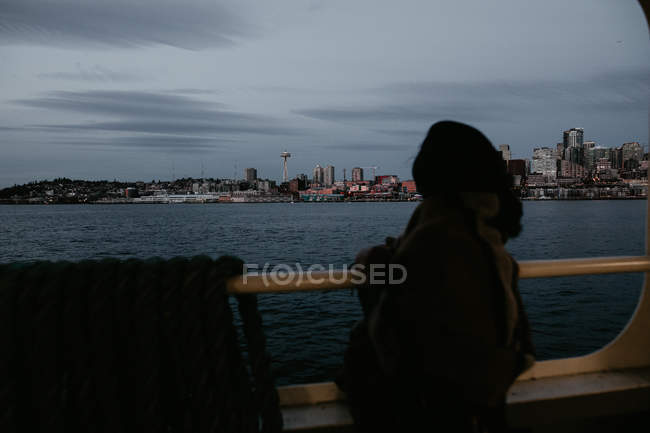 Rear view of woman standing on ferry floor and admiring cityscape — Stock Photo