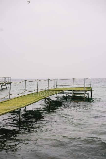 Muelle y mar en tiempo nublado - foto de stock