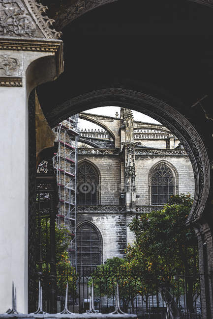 Vista através de arco ornamentado ao detalhe da fachada da igreja — Fotografia de Stock