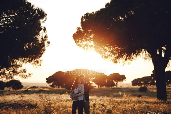Romantic couple embracing in the middle of the field at sunset in Madrid, Spain — Stock Photo