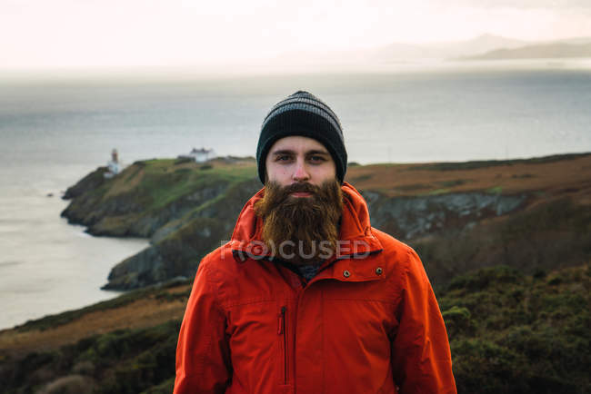 Retrato del hombre posando en las montañas costeras en el día de niebla - foto de stock