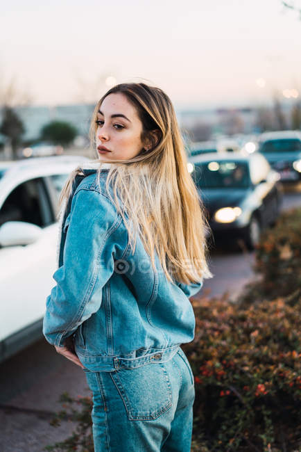 Seitenansicht des blonden Mädchens in Jeans, das über die Schulter hinweg schaut — Stockfoto