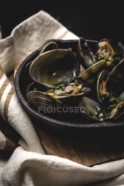 Crop Spanish clam stew in white wine sauce on rustic pan — Stock Photo