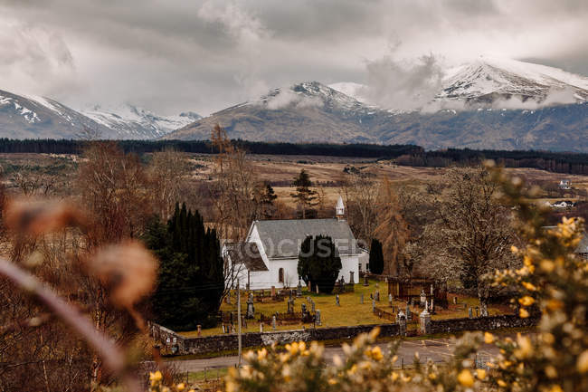 Paisaje con pequeña iglesia en valle de montaña - foto de stock