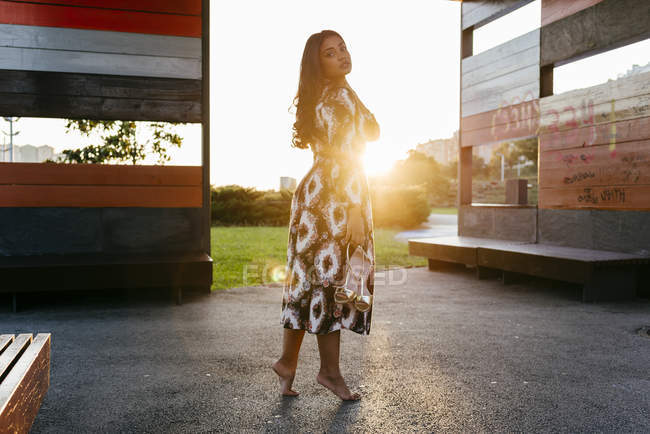 Вид збоку сонячної жінки, що стоїть біля лави — стокове фото