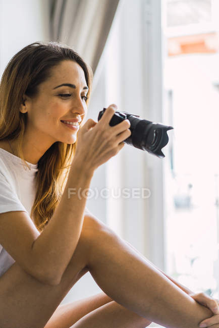 Vista lateral de la mujer tomando fotos con la cámara - foto de stock