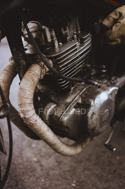 Fragmento de motor metálico de motocicleta en carretera pavimentada . - foto de stock