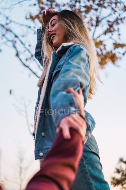 Bottom side view of blonde in denim clothes gesturing follow me — Stock Photo