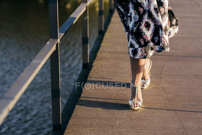 Mulher de seção baixa em belo vestido andando na ponte — Fotografia de Stock