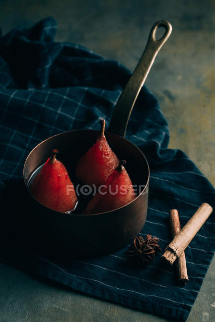 Bodegón de escalfado en peras de vino tinto en olla de salsa en la mesa - foto de stock