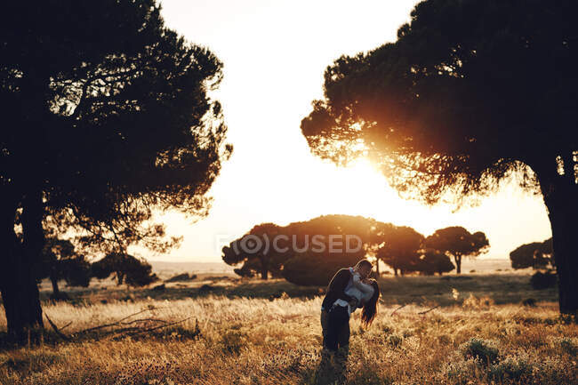 Romantic couple embracing in the middle of the field at sunset in Madrid, Spain — Stock Photo