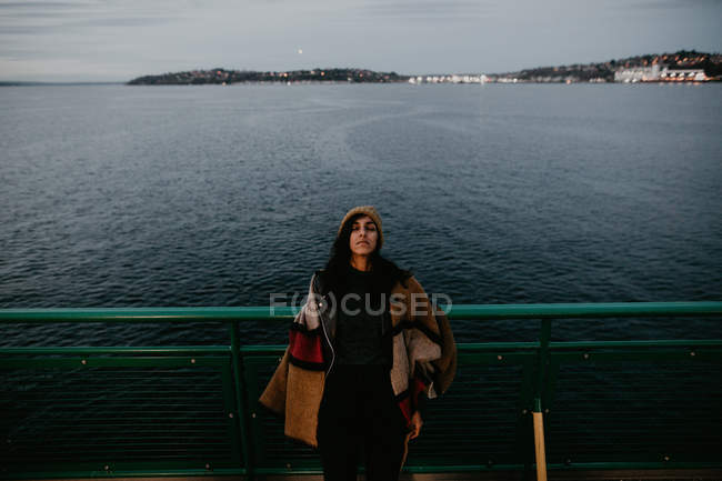 Жінка позує на поромі на фоні моря — стокове фото
