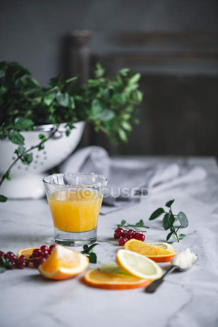 Vista ravvicinata di vetro con succo d'arancia con bacche su tavolo bianco — Foto stock