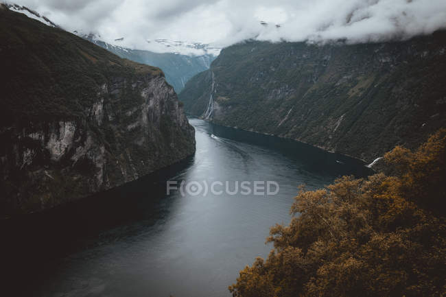 Paisagem de rio que flui entre duas montanhas no fundo de cloudscape — Fotografia de Stock