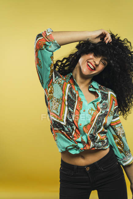 Laughing woman with curly hair posing in studio — Stock Photo