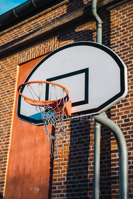 Low angle view of basketball ring on city street. — Stock Photo